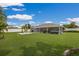 Expansive backyard featuring a screened-in lanai, fire pit area, and lush green lawn at 3889 Canopy Way, Sarasota, FL 34235