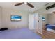Comfortable bedroom with mounted TV, ceiling fan, and large closet with mirrored doors at 3889 Canopy Way, Sarasota, FL 34235
