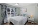 Bright bedroom featuring a queen bed, ceiling fan and a large window letting in ample natural light at 3889 Canopy Way, Sarasota, FL 34235