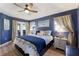 Comfortable bedroom features blue walls, a tray ceiling, and a king bed at 3889 Canopy Way, Sarasota, FL 34235