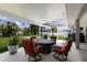 Covered patio showcasing a cozy fire pit with comfortable seating, overlooking a beautifully landscaped backyard at 3889 Canopy Way, Sarasota, FL 34235