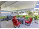Covered patio showcasing a hot tub, fire pit, and comfortable seating area in a landscaped backyard at 3889 Canopy Way, Sarasota, FL 34235