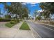 Community entrance with electronic gate access, manicured landscaping, and tree lined entrance drive at 3889 Canopy Way, Sarasota, FL 34235