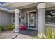 Covered front porch with pillars, wreath and colorful flowers and landscaping at 3889 Canopy Way, Sarasota, FL 34235