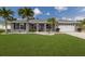 Charming single-Gathering home featuring a lush green lawn and swaying palm trees at 3889 Canopy Way, Sarasota, FL 34235