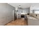 Modern kitchen with grey cabinets, stainless steel appliances, granite countertops, and hardwood floors at 3889 Canopy Way, Sarasota, FL 34235