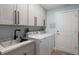 Well-organized laundry room with modern washer/dryer, utility sink, and plenty of storage space at 3889 Canopy Way, Sarasota, FL 34235