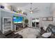 Bright living room featuring access to the patio, a large screen TV, and beach-themed decor at 3889 Canopy Way, Sarasota, FL 34235