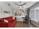Bright office area featuring a tray ceiling, fan, small desk, red sofa, and beach themed decor at 3889 Canopy Way, Sarasota, FL 34235