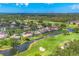 Scenic aerial view of community featuring golf courses, lush trees, serene water, and blue skies at 4356 Highland Oaks Cir # 3, Sarasota, FL 34235