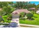 Exterior elevation with lush landscaping, mature trees, and a tile roof at 4356 Highland Oaks Cir # 3, Sarasota, FL 34235