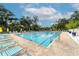 Sparkling outdoor pool with lounge chairs and umbrellas, surrounded by mature trees at 4356 Highland Oaks Cir # 3, Sarasota, FL 34235