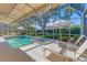Beautiful pool and jacuzzi in a screened lanai, surrounded by lush landscaping and patio furniture at 4356 Highland Oaks Cir # 3, Sarasota, FL 34235