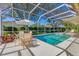 Gorgeous pool and jacuzzi in a screened lanai, surrounded by lush landscaping and patio furniture at 4356 Highland Oaks Cir # 3, Sarasota, FL 34235