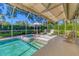 Sparkling pool and jacuzzi in a screened lanai, surrounded by lush landscaping and patio furniture at 4356 Highland Oaks Cir # 3, Sarasota, FL 34235
