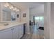 Modern bathroom leading to a bedroom with a view, featuring sleek cabinets and ample lighting at 446 Cerromar Rd # 291, Venice, FL 34293