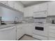 Functional white kitchen featuring essential appliances and ample countertop space for easy meal preparation at 446 Cerromar Rd # 291, Venice, FL 34293