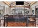 Barrel House bar with a TV, liquor display, marble countertop, seating for bar patrons, and herringbone wood floor at 4750 Tortona Ct, Bradenton, FL 34211