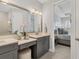 Elegant bathroom with dual vanity, well-lit mirror, and a view to the primary bedroom at 4750 Tortona Ct, Bradenton, FL 34211