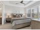 Cozy bedroom featuring tray ceiling, plantation shutters, neutral color palette, and ensuite bathroom at 4750 Tortona Ct, Bradenton, FL 34211