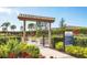 A welcoming community garden entrance features a trellis, sign, colorful plants, and lush landscaping at 4750 Tortona Ct, Bradenton, FL 34211