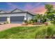 Charming single-story home features a well-manicured lawn, lush landscaping, and a paved walkway to the front entrance at 4750 Tortona Ct, Bradenton, FL 34211