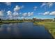 Picturesque view of a golf course along a serene waterfront with lush greenery, highlighting the community's appeal at 4750 Tortona Ct, Bradenton, FL 34211