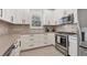 Modern kitchen features stainless steel appliances, white cabinetry, undermount sink, and elegant backsplash at 4750 Tortona Ct, Bradenton, FL 34211