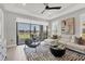 Sun-filled living room features stylish decor and a scenic view of the lake through the large sliding doors at 4750 Tortona Ct, Bradenton, FL 34211
