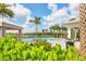 Resort-style pool with lush landscaping, cabana, and lounge chairs on a sunny day at 4750 Tortona Ct, Bradenton, FL 34211