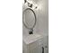 Close up of the bathroom vanity, which includes bronze fixtures and a round mirror above a marble countertop at 4802 51St W St # 107, Bradenton, FL 34210