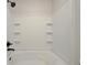 Bathtub with white tile and storage shelves at 4802 51St W St # 107, Bradenton, FL 34210