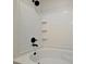 Close up of white tiled bathtub with black fixtures and showerhead at 4802 51St W St # 107, Bradenton, FL 34210