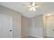 Neutral bedroom featuring a ceiling fan, light wood flooring, and white doors at 4802 51St W St # 107, Bradenton, FL 34210