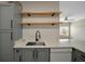 Kitchen with stainless steel sink, white counters and cabinets, and floating wood shelves at 4802 51St W St # 107, Bradenton, FL 34210