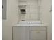 Bright laundry room with stacked shelving over a side-by-side washer and dryer set at 4802 51St W St # 107, Bradenton, FL 34210