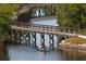 A tranquil waterway features a wooden bridge and a canoe with two people paddling at 4802 51St W St # 107, Bradenton, FL 34210