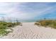 Sandy beach access with lush greenery offering serene ocean views and tranquility at 4968 Gulf Of Mexico Dr # Villa 22, Longboat Key, FL 34228
