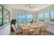 Dining area with ceiling fan and waterfront views through large windows, creating an inviting atmosphere at 4968 Gulf Of Mexico Dr # Villa 22, Longboat Key, FL 34228