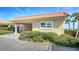 Charming home exterior featuring lush landscaping, a convenient carport, and a durable tile roof at 4968 Gulf Of Mexico Dr # Villa 22, Longboat Key, FL 34228