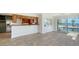 Bright living room with tile flooring, an open kitchen view, and sliding doors to a waterfront view at 4968 Gulf Of Mexico Dr # Villa 22, Longboat Key, FL 34228