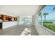 Expansive living area with sleek tile flooring, updated kitchen, and wall-to-wall windows overlooking the water at 4968 Gulf Of Mexico Dr # Villa 22, Longboat Key, FL 34228