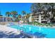 Inviting outdoor pool with lounge chairs, set against a backdrop of palm trees and a multi-story building at 4968 Gulf Of Mexico Dr # Villa 22, Longboat Key, FL 34228