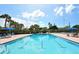 Sparkling swimming pool features lounge seating and lush palm trees on a bright day at 4968 Gulf Of Mexico Dr # Villa 22, Longboat Key, FL 34228