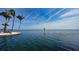 Scenic waterfront featuring palm trees and clear skies over a calm ocean bay at 4968 Gulf Of Mexico Dr # Villa 22, Longboat Key, FL 34228