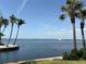 Breathtaking waterfront view with swaying palm trees and stunning blue water on a sunny day at 4968 Gulf Of Mexico Dr # Villa 22, Longboat Key, FL 34228