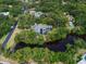 Stunning aerial view of a beautiful home with a pool, surrounded by lush greenery and a tranquil pond at 5282 Box Turtle Cir, Sarasota, FL 34232