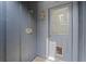 Back door with a pet door on a home with grey siding, lit with a brass colored wall sconce at 5282 Box Turtle Cir, Sarasota, FL 34232