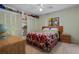 Charming bedroom with a colorful floral bedspread, a ceiling fan, and ample storage with built-in shelving at 5282 Box Turtle Cir, Sarasota, FL 34232