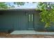 Charming home exterior featuring grey siding and a door with glass panes, enhanced by lush green surroundings at 5282 Box Turtle Cir, Sarasota, FL 34232